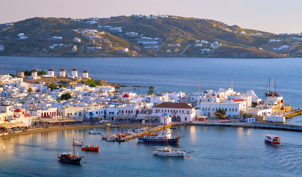 View of the wonderful Mykonos Town. View the iconic Windmills on the left and Panagia Paparortiani in the background right